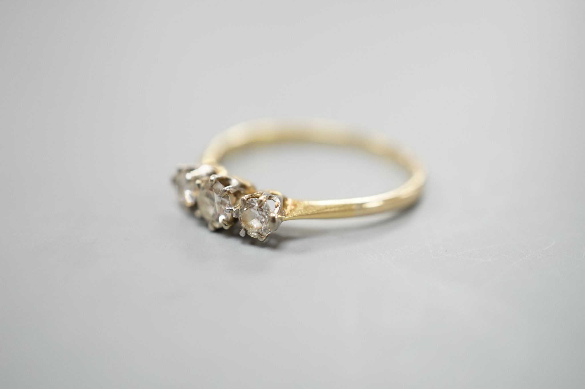 An 18ct and three stone diamond set ring, size P/Q, gross weight 1.7 grams.